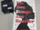 A photo of Esther Okonkwo's The Tiny Things are Heavier alongside a scent bottle on a flat grey surface.